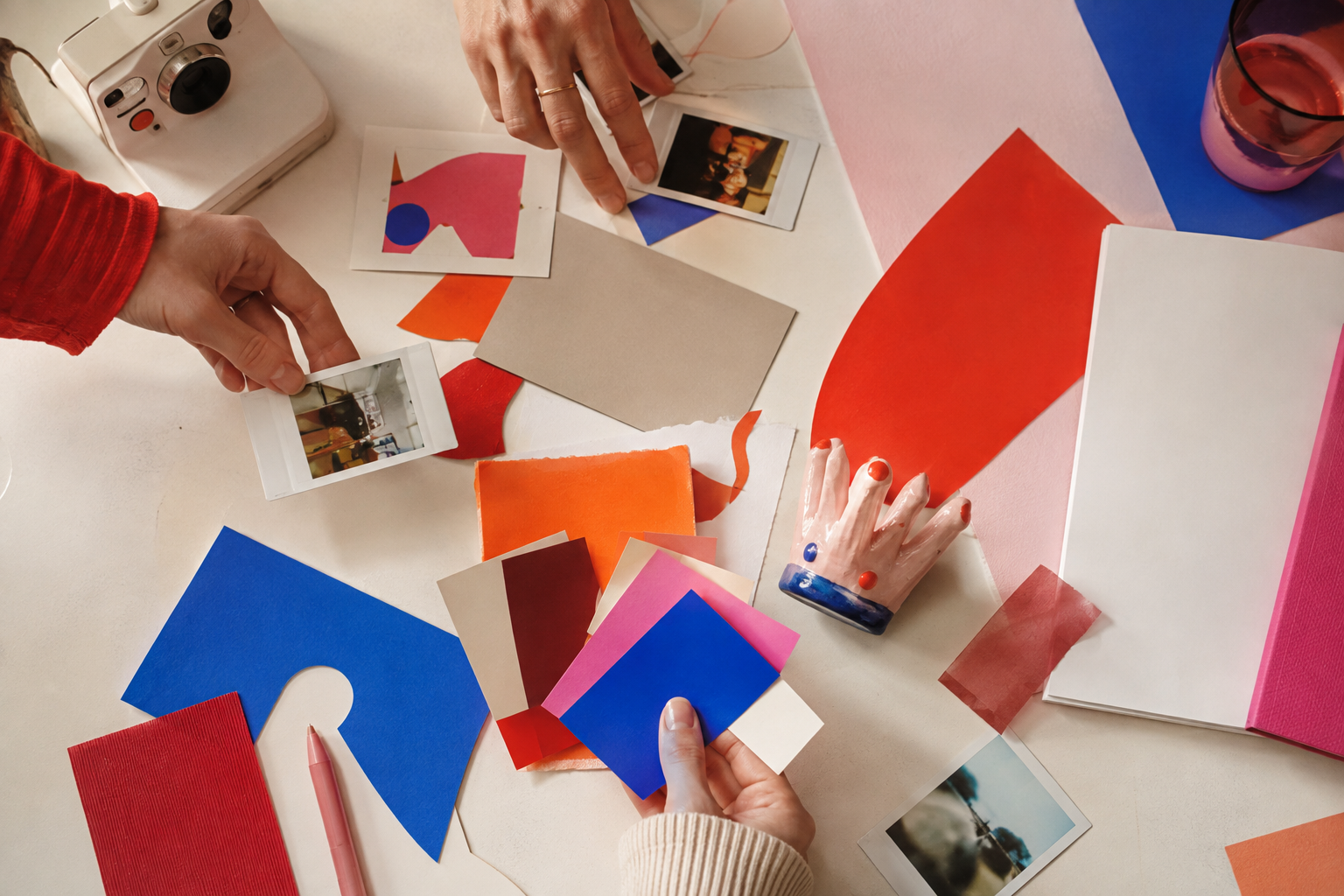 Hands arranging color chips and paper forms on a creative planning table